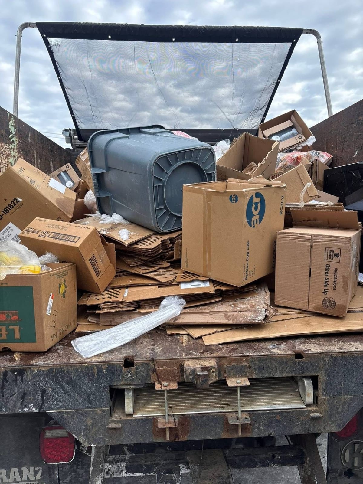 Truck bed loaded with restaurant supply boxes and cardboard