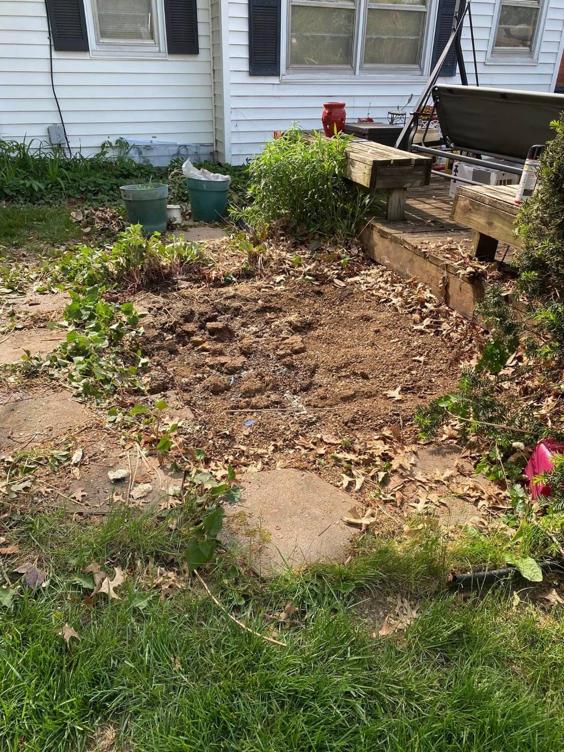 The same spot beside the deck after the hot tub was removed, leaving bare dirt
